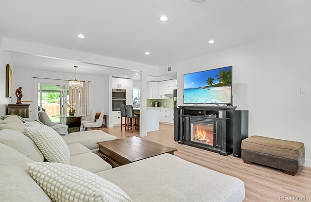 living room with a chandelier and light wood-type flooring