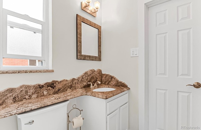 bathroom featuring a healthy amount of sunlight, toilet, and vanity