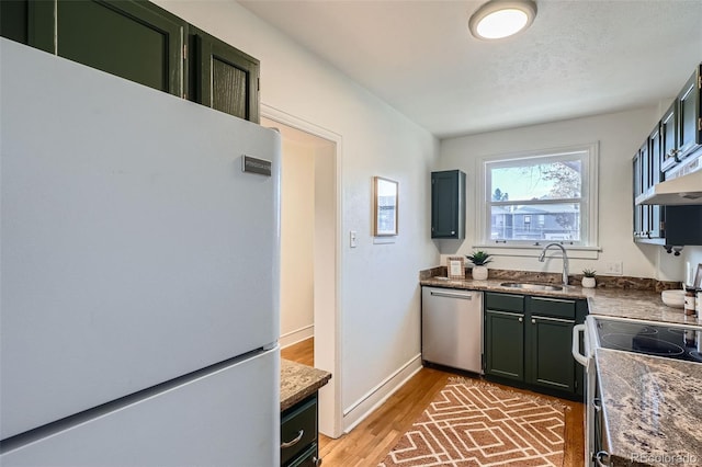 kitchen featuring dark stone countertops, sink, white appliances, a textured ceiling, and dark hardwood / wood-style flooring