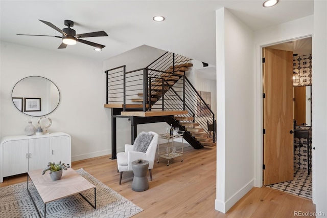 stairs featuring ceiling fan and wood-type flooring