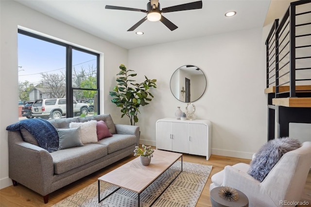 living room featuring ceiling fan and light hardwood / wood-style flooring