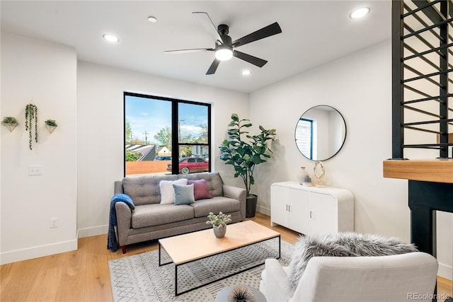 living room with ceiling fan and light hardwood / wood-style flooring