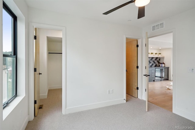 unfurnished bedroom featuring light carpet and ceiling fan