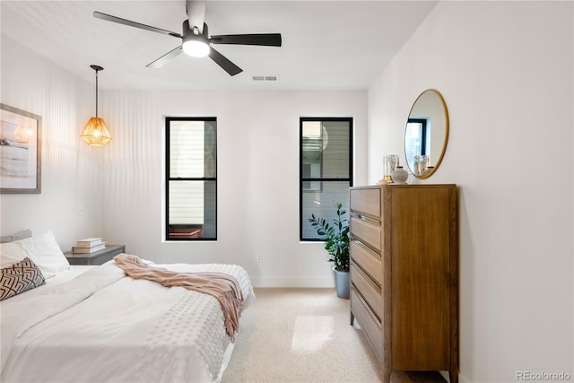 bedroom with multiple windows, light colored carpet, and ceiling fan