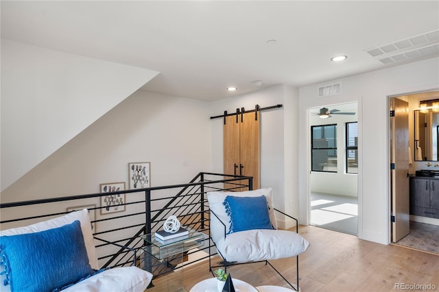 sitting room featuring a barn door and light wood-type flooring