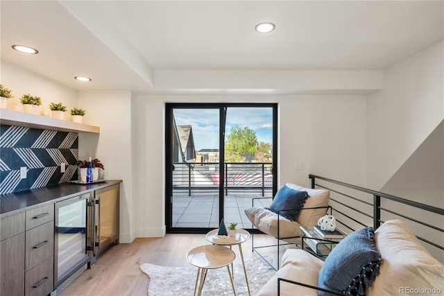 living area with wine cooler and light hardwood / wood-style flooring