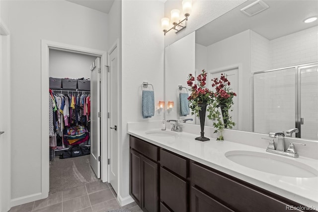 bathroom featuring walk in shower, vanity, and tile patterned flooring