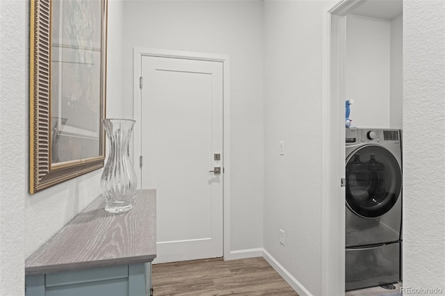 washroom with light wood-type flooring and washer / dryer