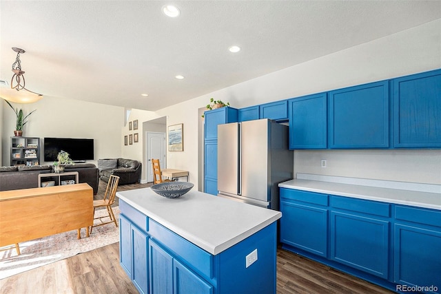 kitchen with dark wood finished floors, freestanding refrigerator, and blue cabinets