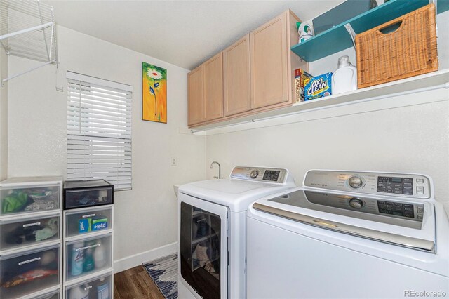 clothes washing area with dark wood-style floors, washer and dryer, cabinet space, and baseboards