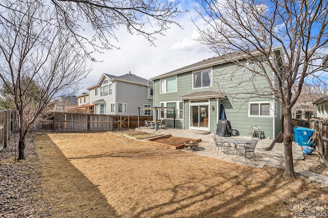 rear view of house with a fenced backyard and a patio