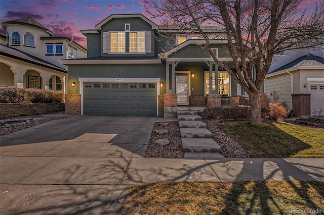 view of front of house with brick siding, stucco siding, a porch, an attached garage, and driveway