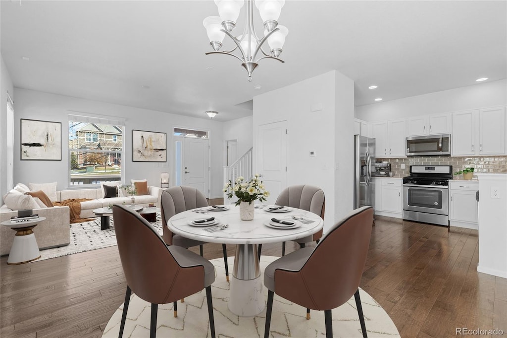 dining area with dark wood-type flooring and a notable chandelier