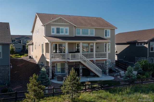 8761 S Wenatchee Ct, Aurora, CO 80016 - rear view of house featuring a patio, stairway, stone siding, and a shingled roof