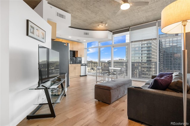 living room featuring light wood-type flooring, a wall of windows, and ceiling fan