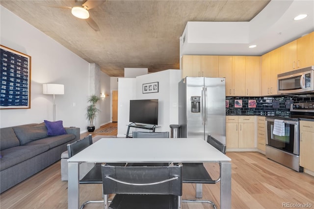 kitchen with decorative backsplash, appliances with stainless steel finishes, light wood-type flooring, and light brown cabinetry