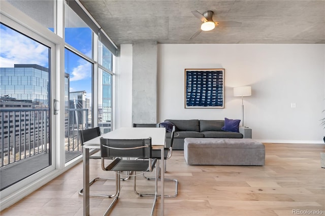 living room featuring a wall of windows, light hardwood / wood-style floors, and ceiling fan