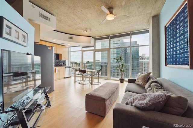 living room featuring floor to ceiling windows, ceiling fan, and light wood-type flooring