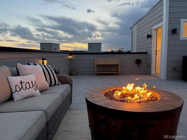 12261 Farmview St, Thornton, CO 80241 - patio terrace at dusk with an outdoor living space with a fire pit and a patio