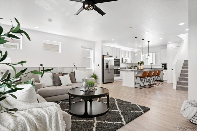 12261 Farmview St, Thornton, CO 80241 - living area featuring a ceiling fan, light wood-style flooring, stairway, and recessed lighting