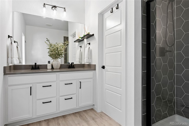 12261 Farmview St, Thornton, CO 80241 - full bath with double vanity, tiled shower, and wood finished floors