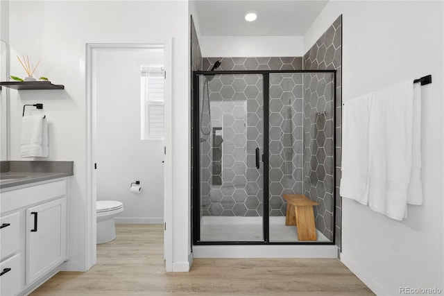 12261 Farmview St, Thornton, CO 80241 - bathroom with a stall shower, toilet, vanity, wood finished floors, and baseboards