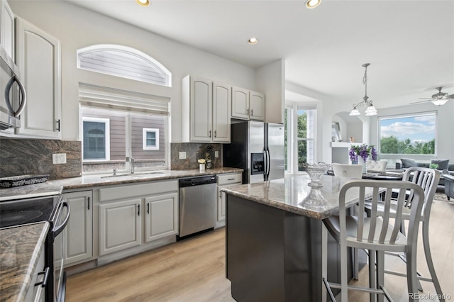 kitchen featuring appliances with stainless steel finishes, tasteful backsplash, pendant lighting, and sink