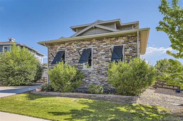 26591 E Calhoun Pl, Aurora, CO 80016 - view of front of home with a front lawn, stone siding, and board and batten siding