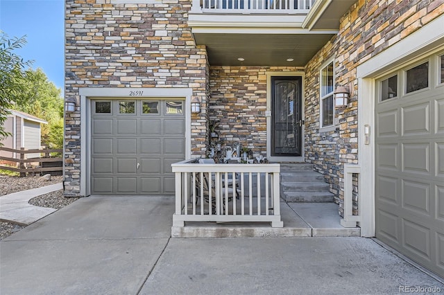 26591 E Calhoun Pl, Aurora, CO 80016 - property entrance with stone siding, concrete driveway, and a garage