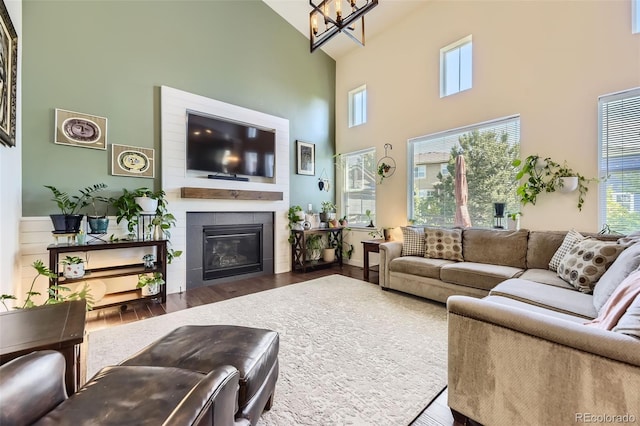 26591 E Calhoun Pl, Aurora, CO 80016 - living area featuring high vaulted ceiling, wood finished floors, a chandelier, a glass covered fireplace, and healthy amount of natural light