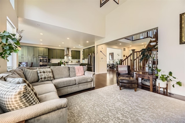 26591 E Calhoun Pl, Aurora, CO 80016 - living area featuring dark wood-style flooring, stairway, plenty of natural light, a high ceiling, and recessed lighting