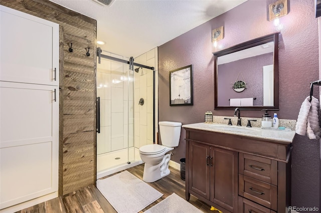 26591 E Calhoun Pl, Aurora, CO 80016 - full bathroom featuring a textured wall, wood finished floors, a stall shower, and vanity