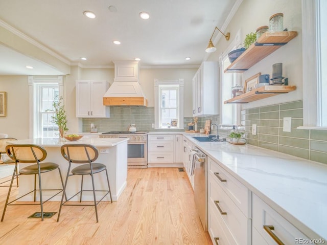 541 Fox St, Denver, CO 80204 - kitchen featuring stainless steel appliances, premium range hood, a breakfast bar, open shelves, and light wood-style floors