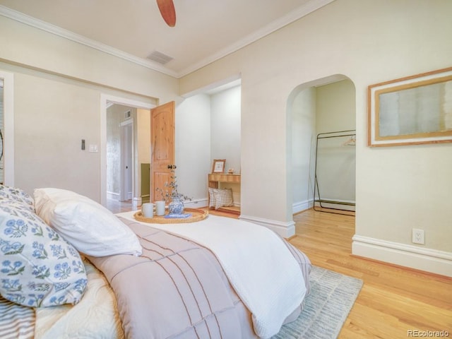 541 Fox St, Denver, CO 80204 - bedroom featuring wood finished floors, crown molding, arched walkways, and a ceiling fan