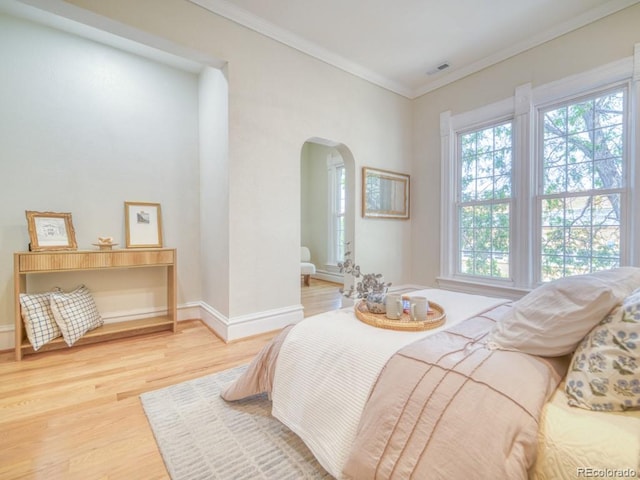 541 Fox St, Denver, CO 80204 - bedroom featuring arched walkways, multiple windows, light wood finished floors, and crown molding