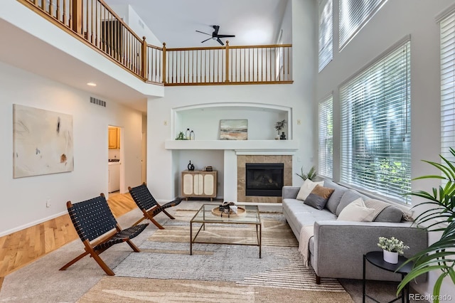 11729 Elmer Linn Dr, Longmont, CO 80504 - living area with a towering ceiling, a ceiling fan, a tile fireplace, and wood finished floors