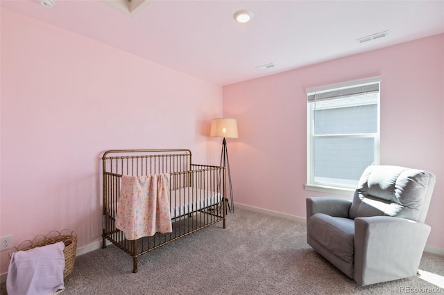 carpeted bedroom featuring visible vents, a crib, and baseboards