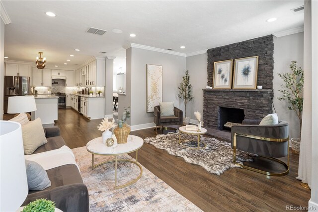 420 N Colorado Blvd, Denver, CO 80206 - living room featuring dark wood-type flooring, a stone fireplace, ornamental molding, baseboards, and recessed lighting