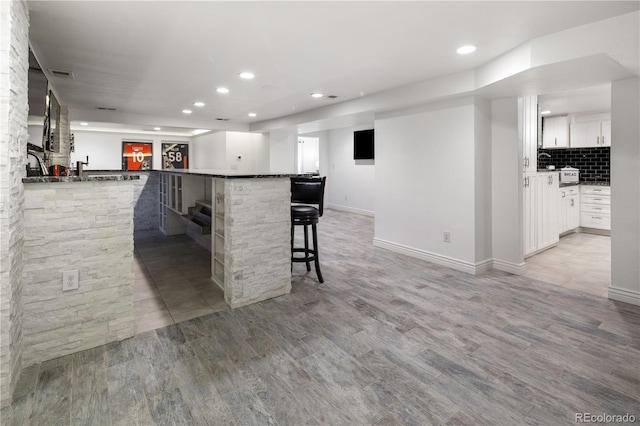 420 N Colorado Blvd, Denver, CO 80206 - kitchen featuring a kitchen breakfast bar, recessed lighting, light wood-type flooring, white cabinetry, and backsplash