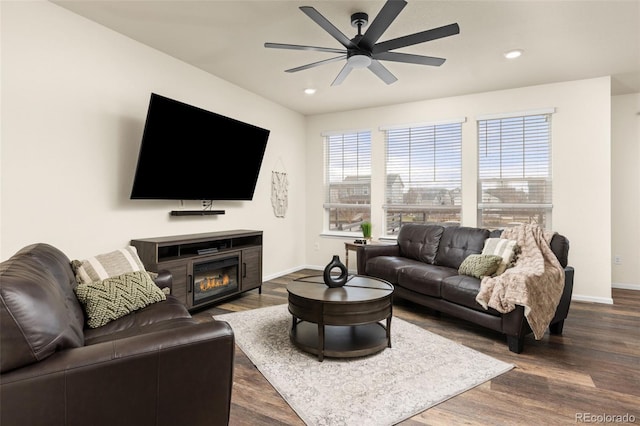 living room featuring ceiling fan and dark wood-type flooring