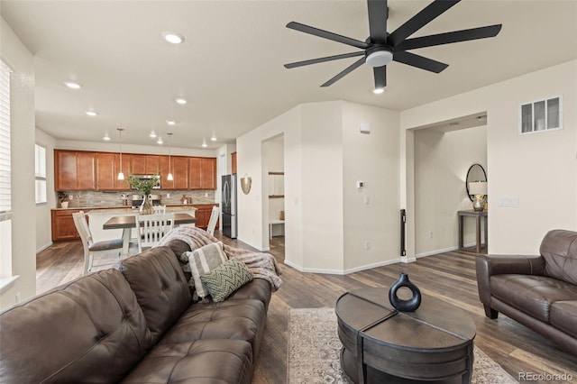 living room with dark hardwood / wood-style flooring and ceiling fan