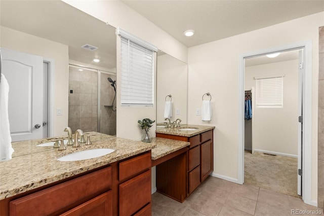 bathroom featuring tile patterned flooring, vanity, and an enclosed shower