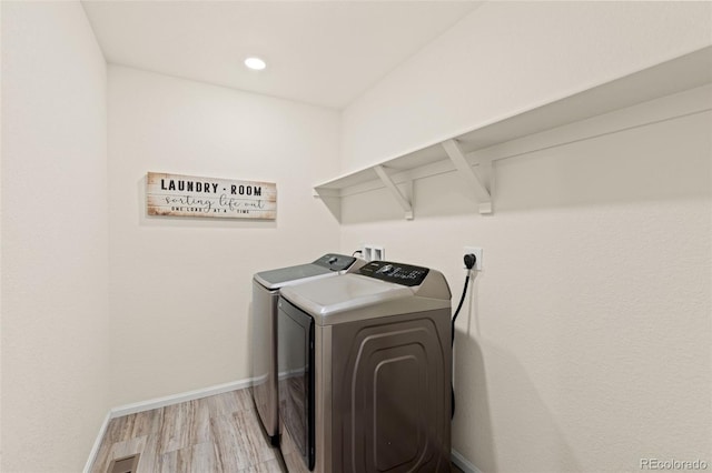 washroom with light wood-type flooring and separate washer and dryer