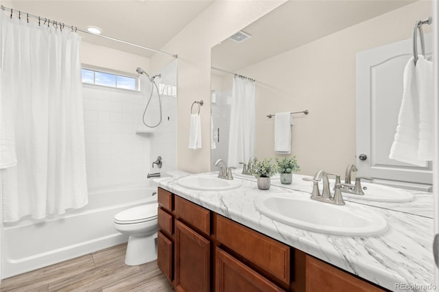 full bathroom featuring vanity, shower / bathtub combination with curtain, and toilet