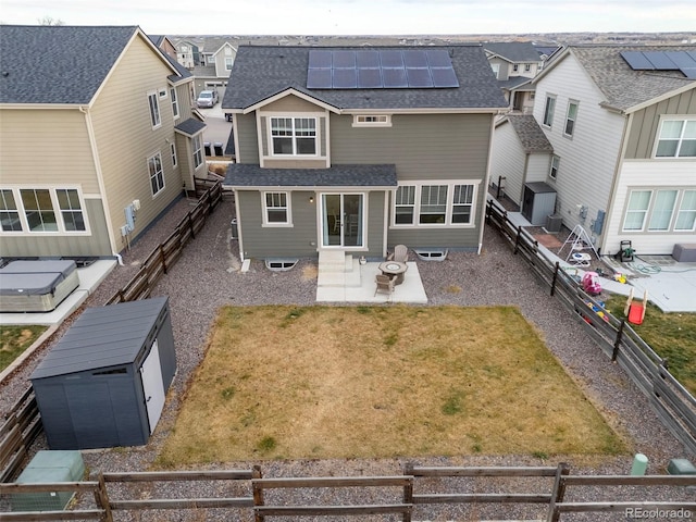 rear view of house with a lawn, solar panels, and a patio area