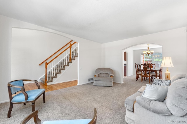 3102 White Oak Trl, Highlands Ranch, CO 80129 - living room with arched walkways, a chandelier, carpet floors, stairs, and baseboards