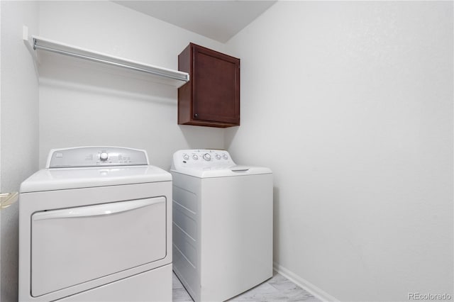 3102 White Oak Trl, Highlands Ranch, CO 80129 - laundry area featuring washing machine and dryer, light marble finish flooring, cabinet space, and baseboards