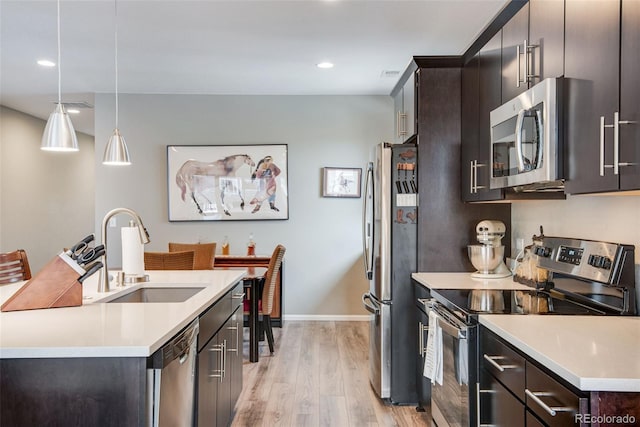 3022 Merlin Dr, Brighton, CO 80601 - kitchen featuring stainless steel appliances, a sink, light wood-type flooring, light countertops, and recessed lighting