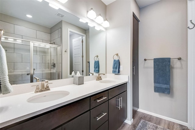 3022 Merlin Dr, Brighton, CO 80601 - full bath featuring double vanity, wood finished floors, a stall shower, and baseboards