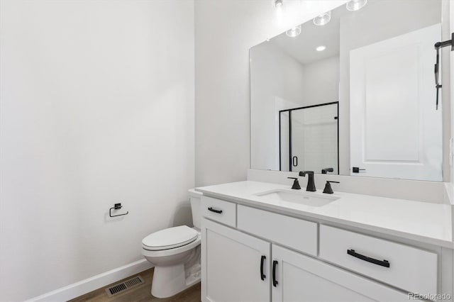 bathroom featuring toilet, an enclosed shower, wood-type flooring, and vanity